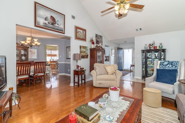 living room featuring high vaulted ceiling, light wood-style flooring, visible vents, and baseboards