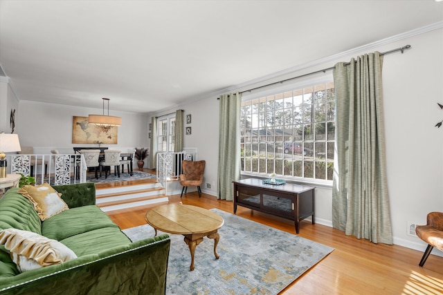 living room with light wood-type flooring and ornamental molding