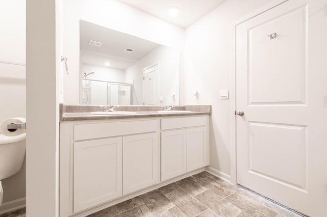 950 Quaint Parish Cir, Graniteville, SC 29829 - bathroom with a sink, double vanity, toilet, baseboards, and a shower stall