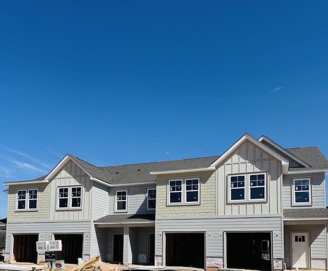 multi unit property with an attached garage, a shingled roof, and board and batten siding