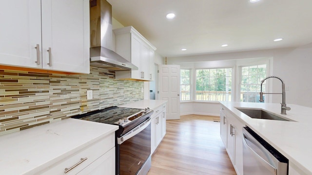 122 Ehrlich Farm Rd, Swainsboro, GA 30401 - kitchen featuring appliances with stainless steel finishes, wall chimney range hood, light wood finished floors, light countertops, and decorative backsplash