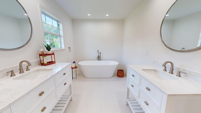 122 Ehrlich Farm Rd, Swainsboro, GA 30401 - bathroom with two vanities, a freestanding bath, and recessed lighting