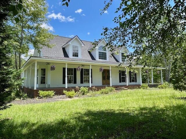 122 Ehrlich Farm Rd, Swainsboro, GA 30401 - farmhouse-style home featuring a porch, a front lawn, and a shingled roof