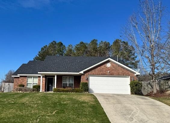 ranch-style house featuring a garage and a front lawn