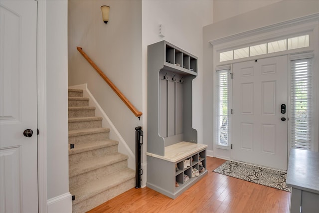 entrance foyer with light wood-style floors, stairway, and baseboards