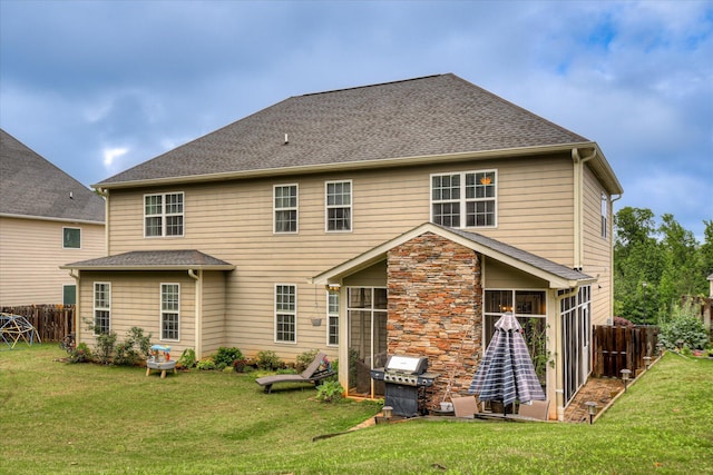 back of house with a sunroom and a shingled roof