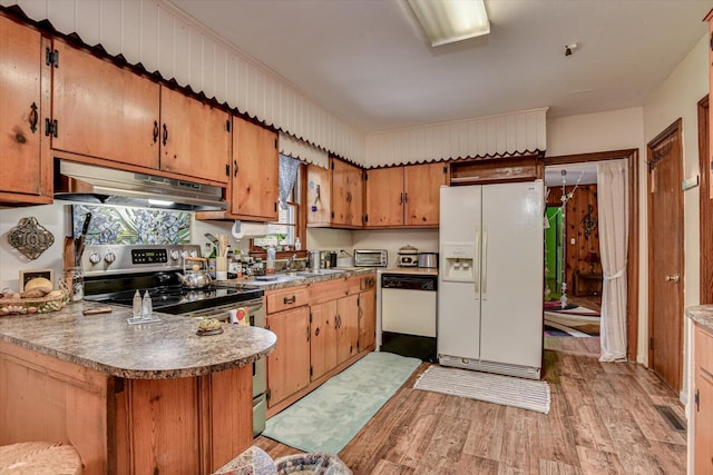 413 Dixie Dr, Thomson, GA 30824 - kitchen featuring white appliances, under cabinet range hood, light wood-style floors, brown cabinetry, and a peninsula