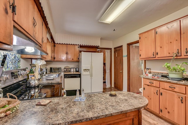 413 Dixie Dr, Thomson, GA 30824 - kitchen featuring white appliances, under cabinet range hood, a peninsula, light wood-type flooring, and brown cabinets