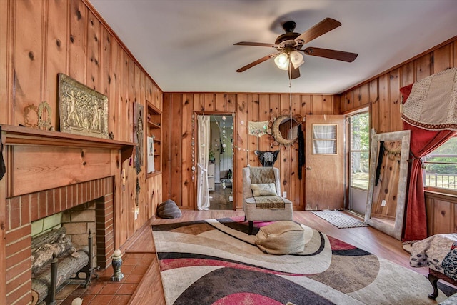 413 Dixie Dr, Thomson, GA 30824 - living area with wooden walls, a ceiling fan, built in shelves, a brick fireplace, and wood finished floors