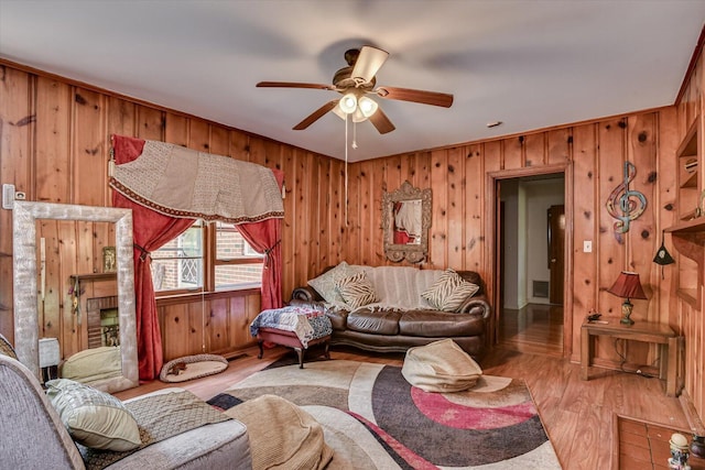413 Dixie Dr, Thomson, GA 30824 - living area featuring wood walls, a ceiling fan, and light wood-style flooring