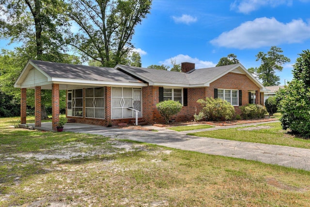 413 Dixie Dr, Thomson, GA 30824 - ranch-style house featuring brick siding, a sunroom, a front yard, and a chimney