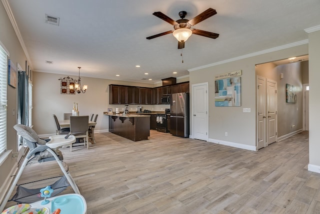 kitchen with dark brown cabinetry, hanging light fixtures, light hardwood / wood-style flooring, a breakfast bar area, and appliances with stainless steel finishes