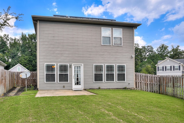 back of house featuring a patio area and a lawn