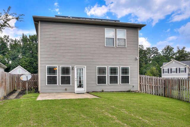 back of house featuring a patio area and a lawn