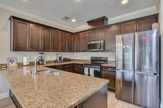 kitchen featuring sink, stainless steel appliances, light stone counters, kitchen peninsula, and dark brown cabinets