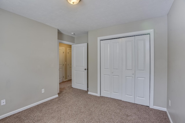 unfurnished bedroom featuring light colored carpet and a closet