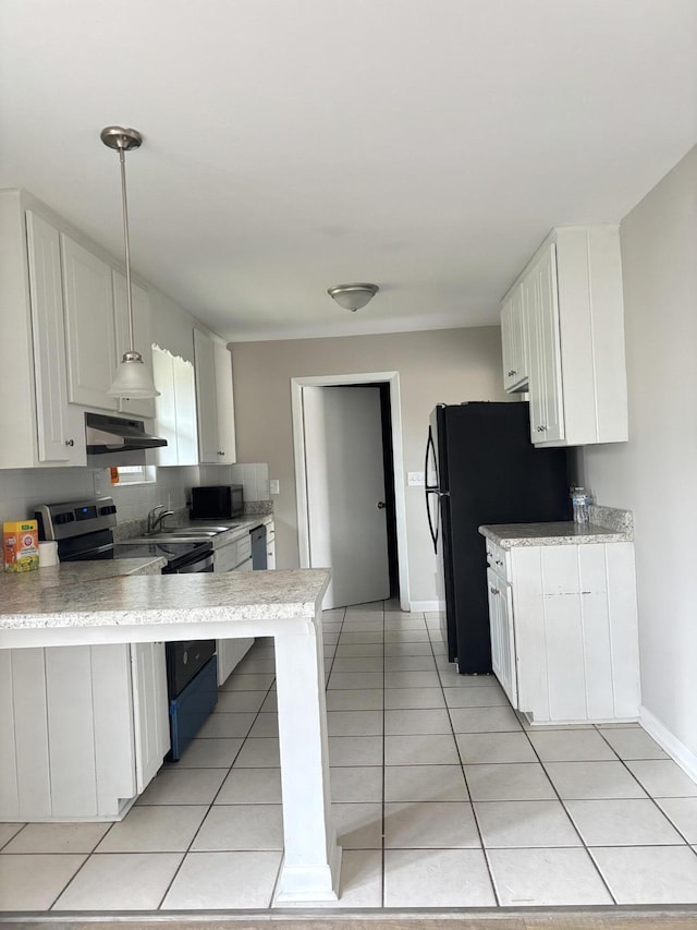 kitchen with kitchen peninsula, black refrigerator, hanging light fixtures, light tile patterned floors, and white cabinets