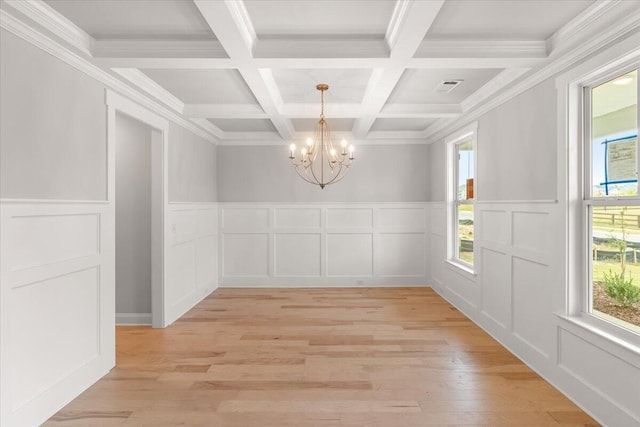 unfurnished dining area featuring coffered ceiling, beam ceiling, light hardwood / wood-style floors, and a chandelier