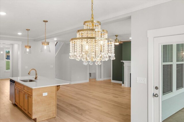 kitchen featuring an island with sink, sink, stainless steel dishwasher, and light wood-type flooring