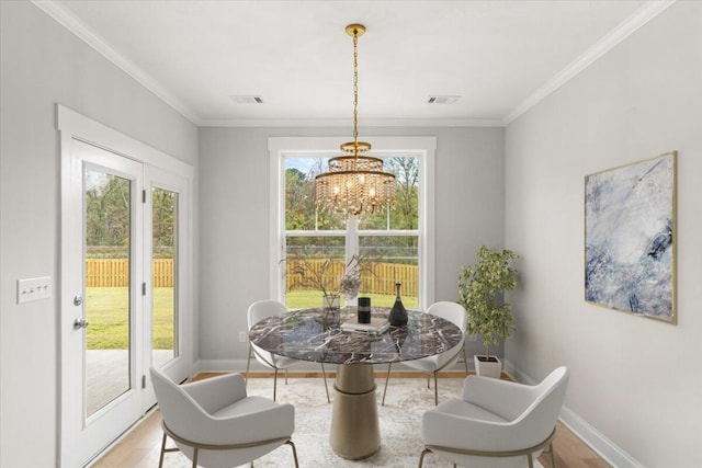 dining room featuring hardwood / wood-style flooring, crown molding, and an inviting chandelier