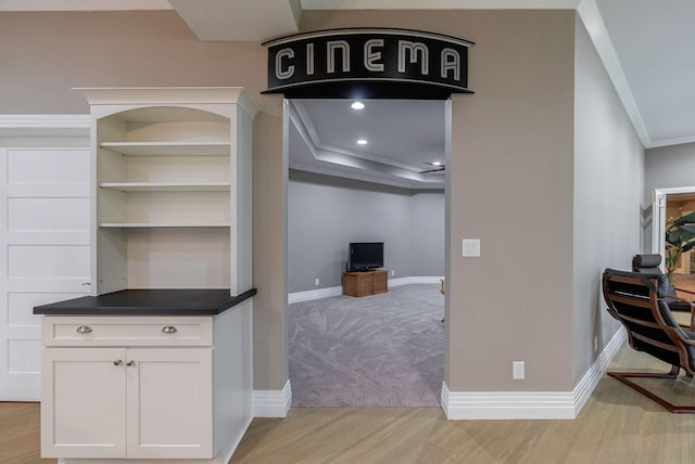 interior space with white cabinetry, crown molding, and light hardwood / wood-style flooring