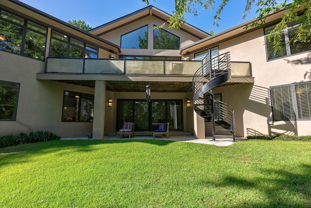 back of house featuring a balcony, a patio area, and a lawn