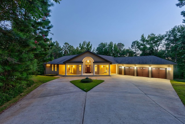 single story home with a garage and a lawn