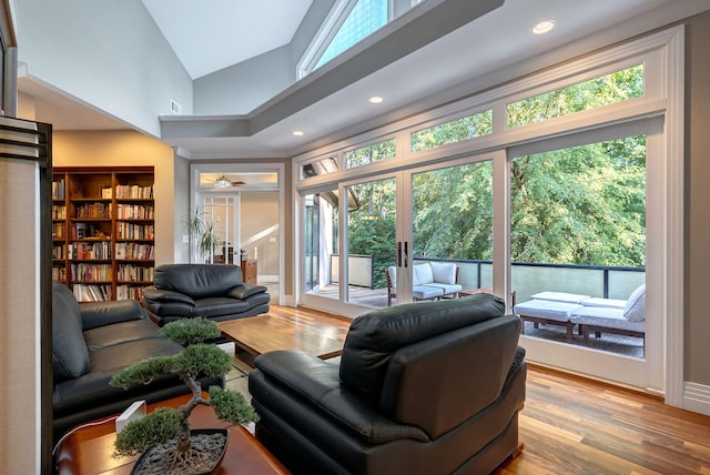 living room with ceiling fan, light hardwood / wood-style flooring, high vaulted ceiling, and french doors