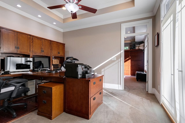 office featuring light carpet, a raised ceiling, and ceiling fan