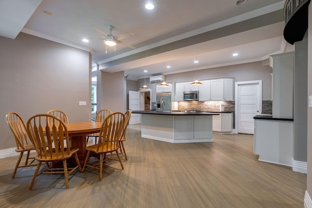 dining room with light hardwood / wood-style flooring, ceiling fan, and crown molding