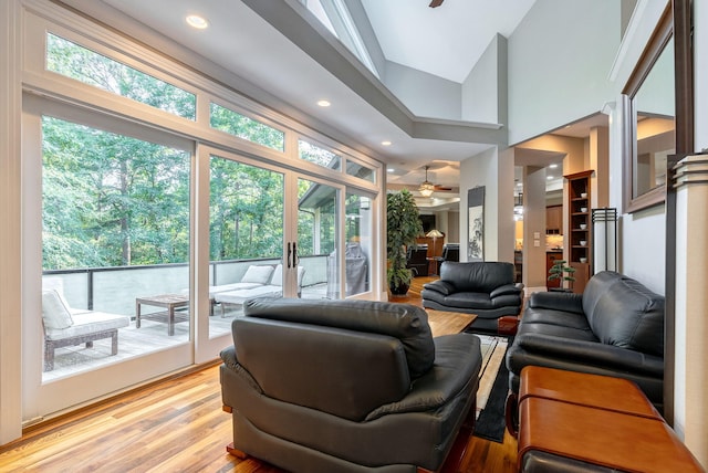 living room with ceiling fan, high vaulted ceiling, and light hardwood / wood-style floors