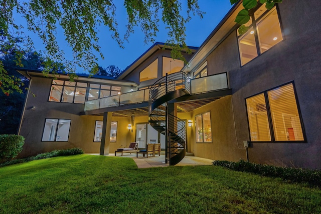 back of house with a lawn, a patio area, and a balcony