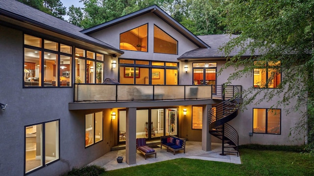 rear view of property with a balcony, a yard, and a patio