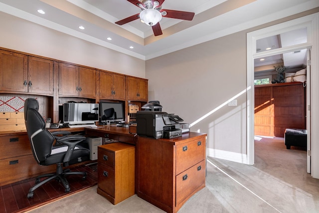 carpeted office with ceiling fan, crown molding, and a high ceiling