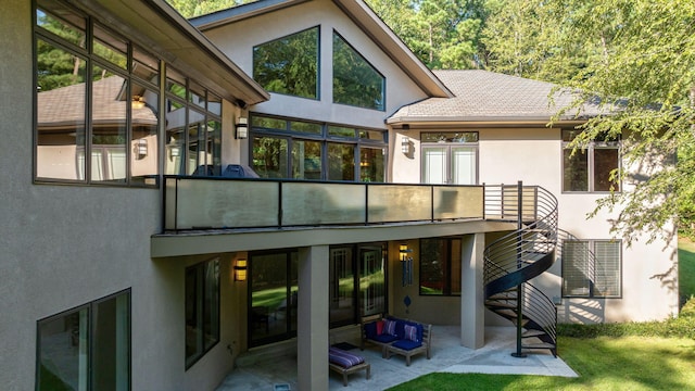 rear view of property featuring a patio and a balcony