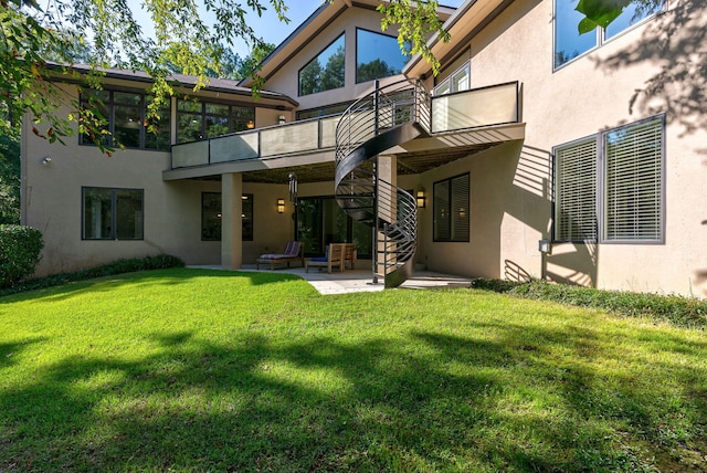 back of property featuring a lawn, a patio area, and a balcony