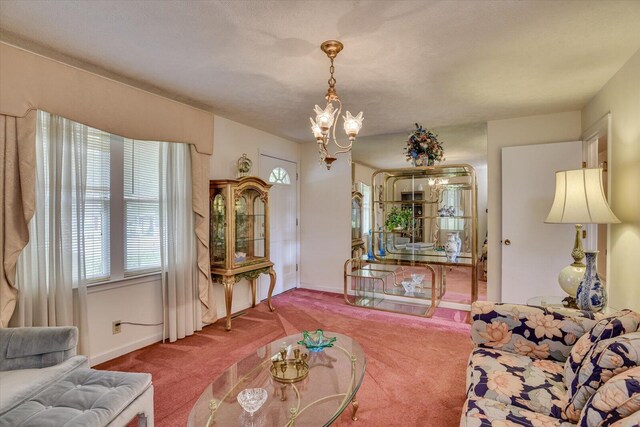 living room featuring carpet, a textured ceiling, and an inviting chandelier