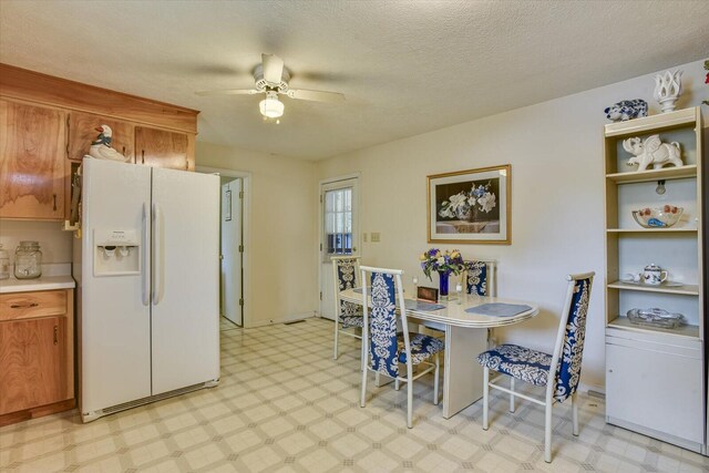 kitchen with white refrigerator with ice dispenser, a textured ceiling, and ceiling fan