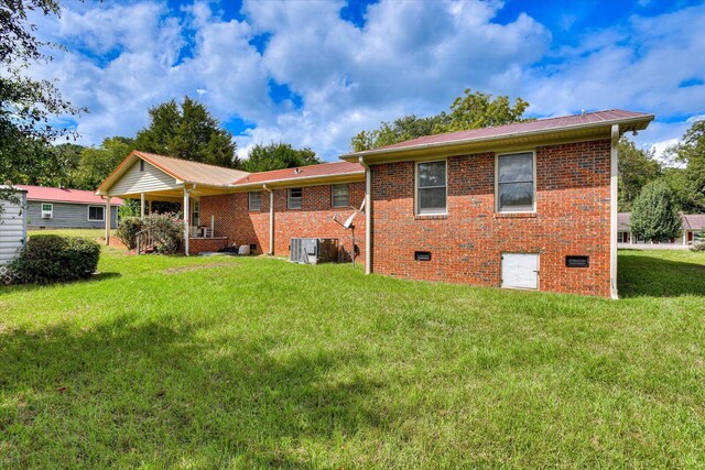 back of property with a lawn and cooling unit