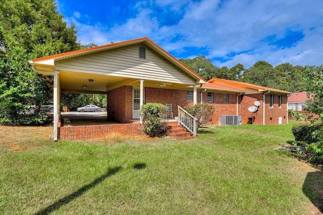 view of front of house with a front yard, a carport, and central air condition unit