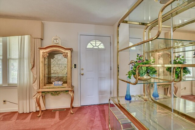 carpeted entryway with a textured ceiling