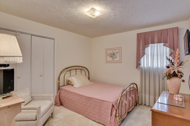 bedroom featuring a textured ceiling and a closet