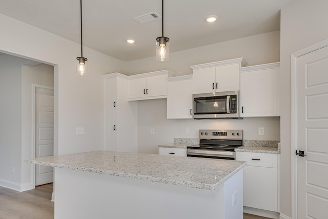 1663 Pine Ridge Dr N, Hephzibah, GA 30815 - kitchen with appliances with stainless steel finishes, white cabinets, light wood-style floors, a kitchen island, and light stone counters