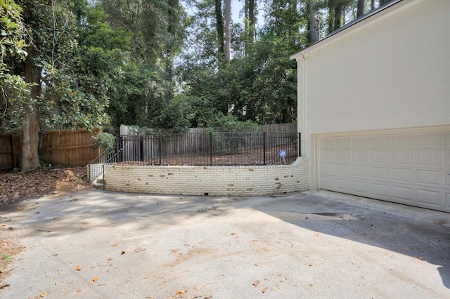2911 Lombardy Ct, Augusta, GA 30909 - view of patio / terrace with a garage, concrete driveway, and view of scattered trees