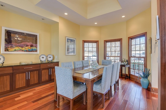 dining room with wood-type flooring and a high ceiling