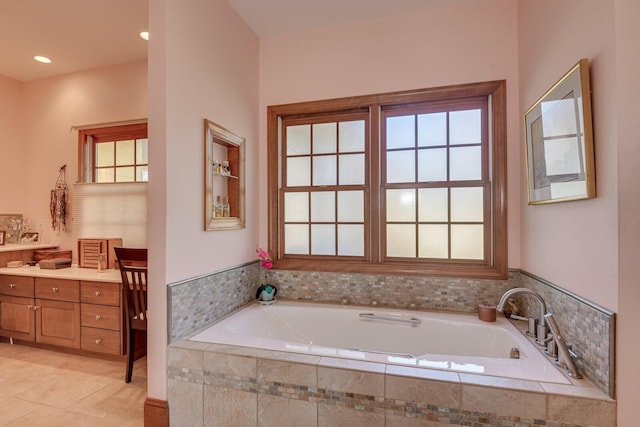 bathroom featuring tile patterned floors, tiled tub, and vanity