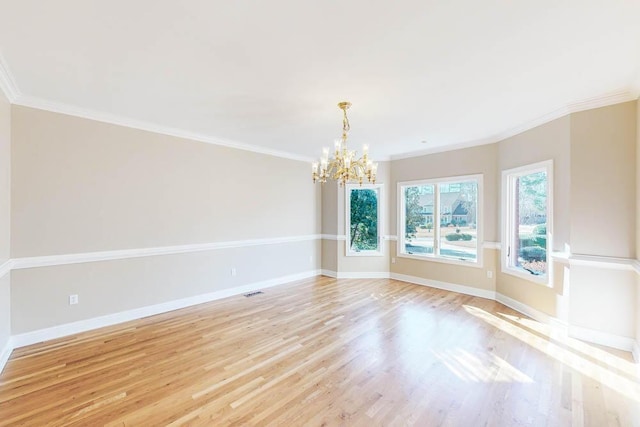 empty room featuring a chandelier, light hardwood / wood-style floors, and ornamental molding