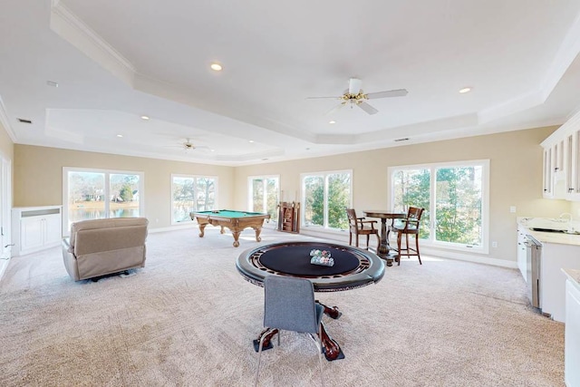 rec room featuring a tray ceiling, ceiling fan, and light colored carpet