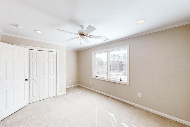 unfurnished bedroom with ceiling fan, ornamental molding, light carpet, and a closet