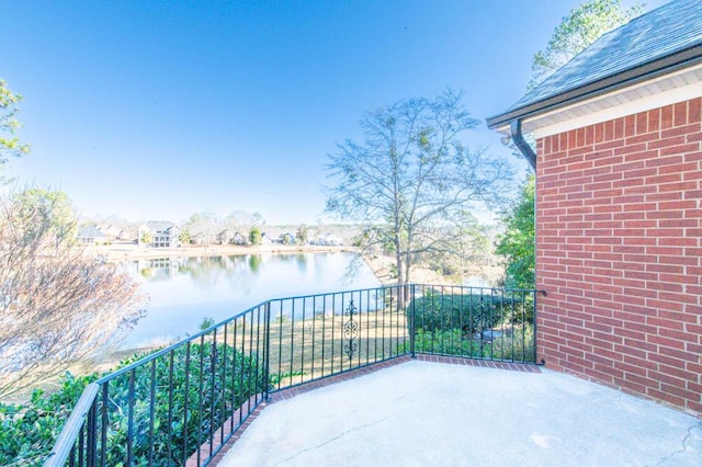 view of patio with a water view and a balcony